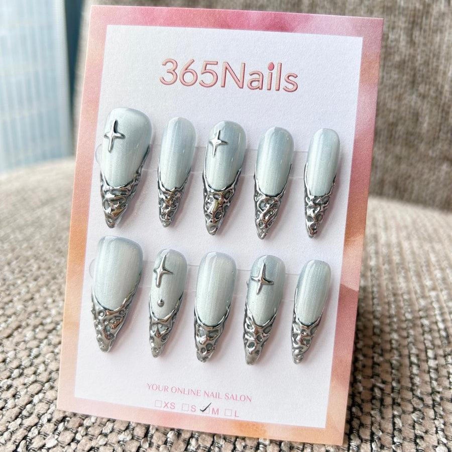 Femme Fatale : « Fonte glaciaire argentée » – base œil de chat blanc glacé avec french 3D chrome liquide et étoiles argentées — ongles press-on longs forme stiletto