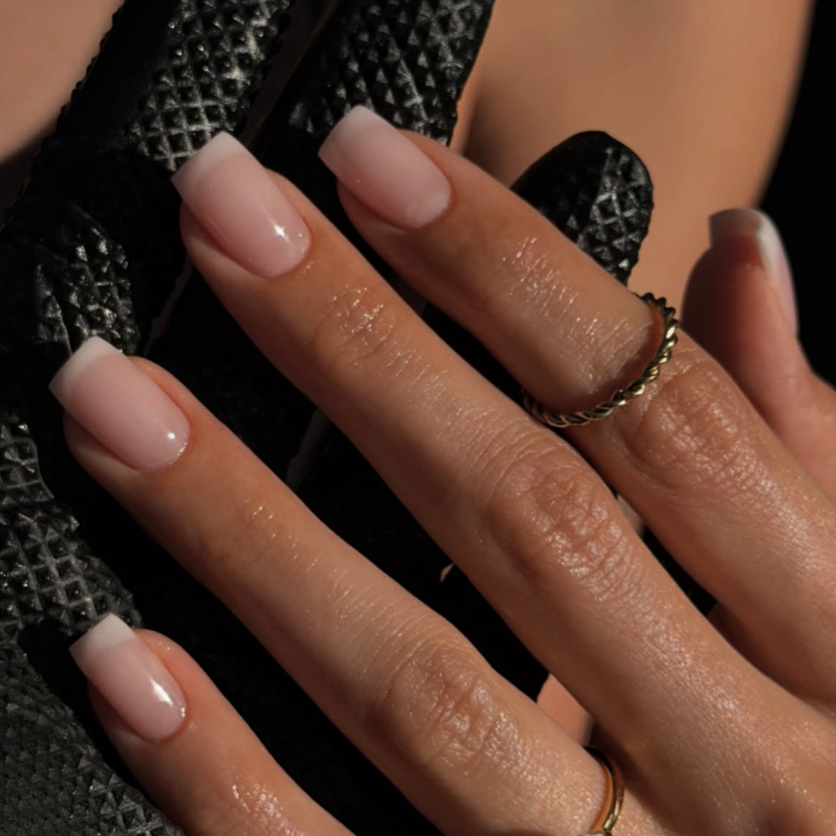 Hand wearing glossy pink nude squoval press-on nails