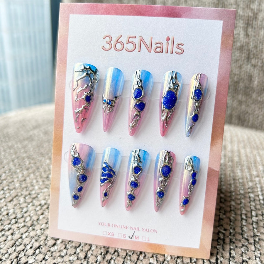 Femme Fatale: "Aurore Cyber" – base nacrée dégradée rose et bleue avec chrome argent liquide 3D et gemmes galaxie bleu profond, ongles press-on longs forme stiletto