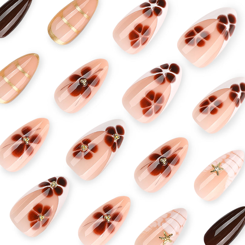 Close-up of floral and gold-striped almond press-on nails