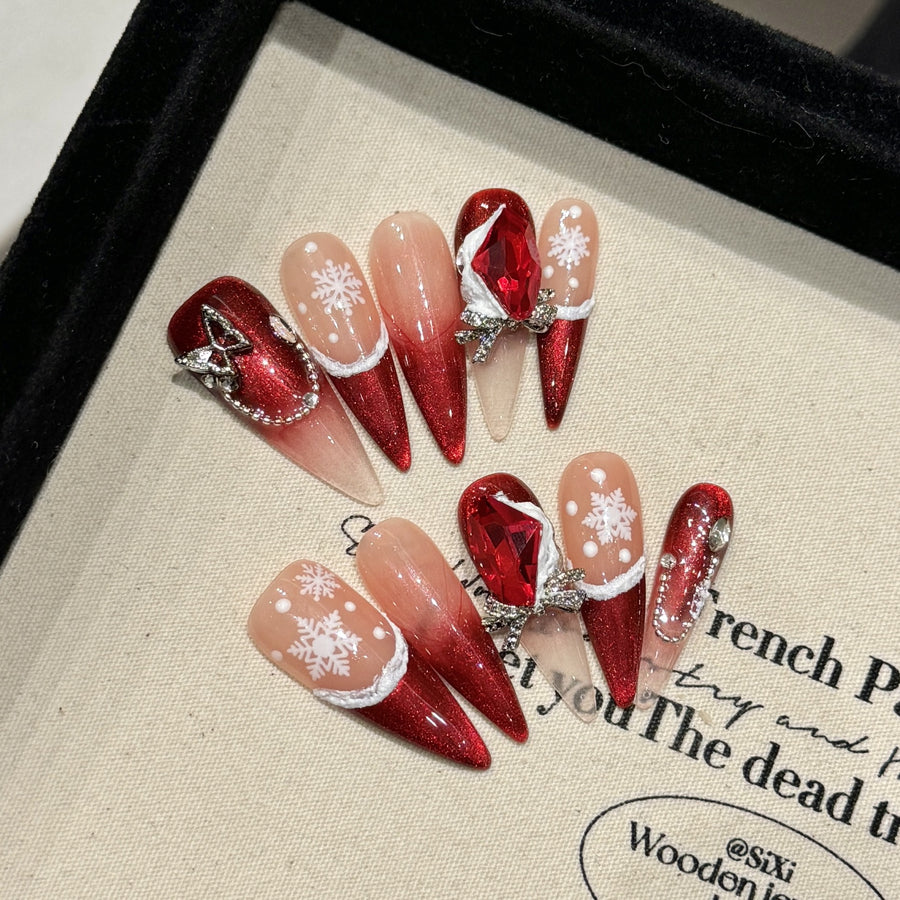 Ongles press-on de Noël à dégradé rouge — motif flocon et nœud orné de gemme
