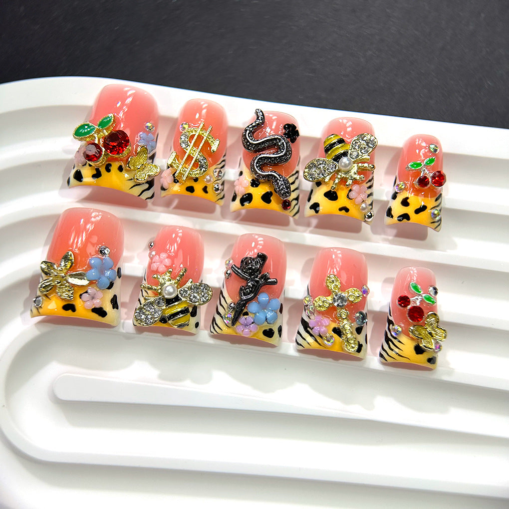 粉色豹紋甲，搭配櫻桃、蜜蜂與金色吊飾