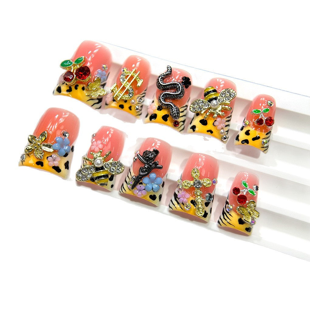 粉色豹紋甲，搭配櫻桃、蜜蜂與金色吊飾