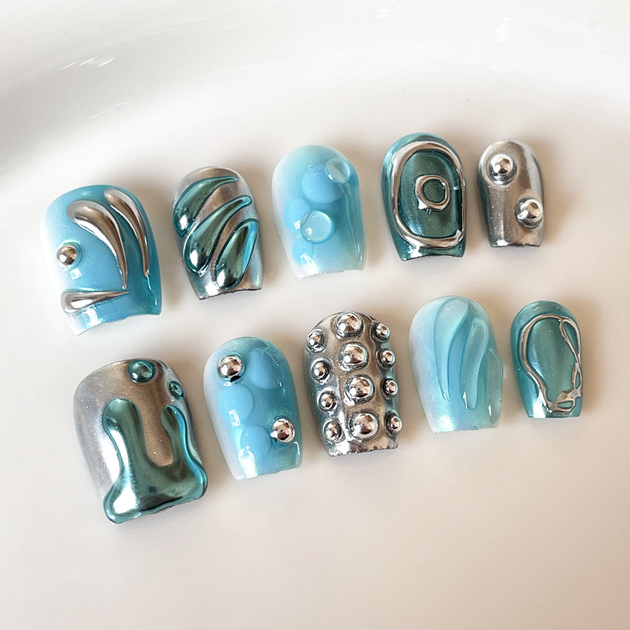 Ongles press-on modernes avec accents chrome bleu et clous métalliques 3D