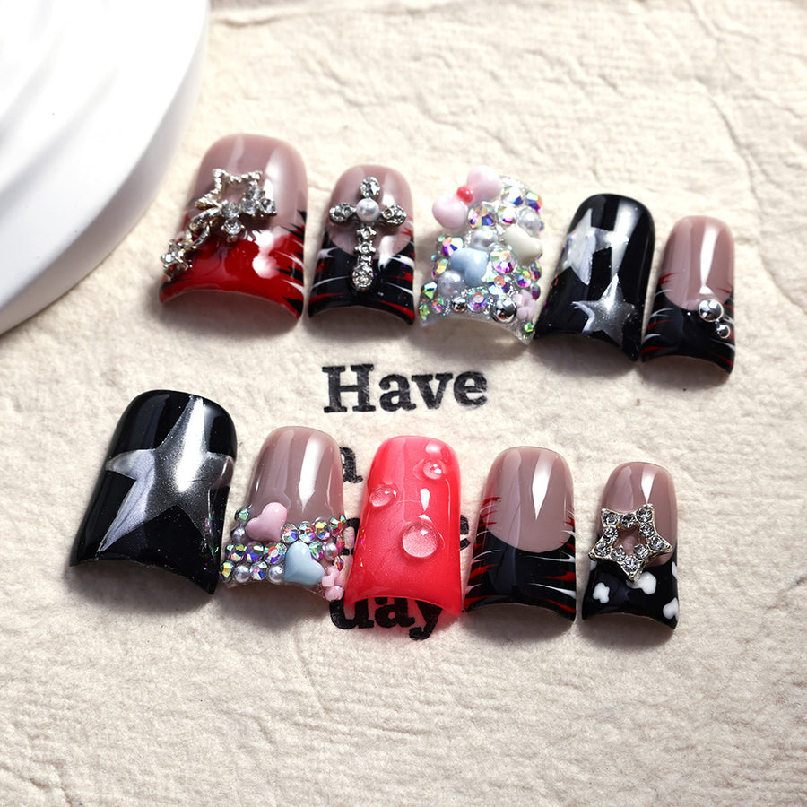 Ongles noirs et rouges avec étoiles, croix et accents en cristaux