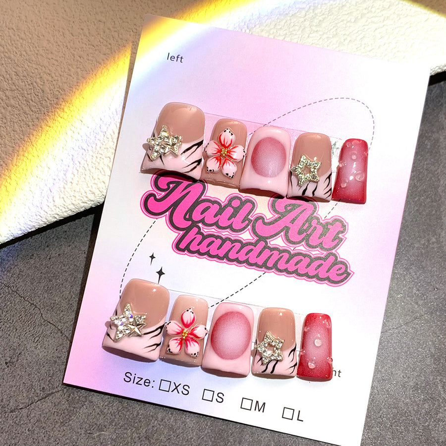 Ongles press-on nude et rouge, motifs étoiles et fleurs