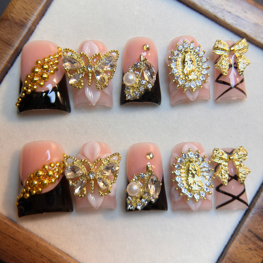 Ongles press-on noir et doré, nœud baroque — style luxe