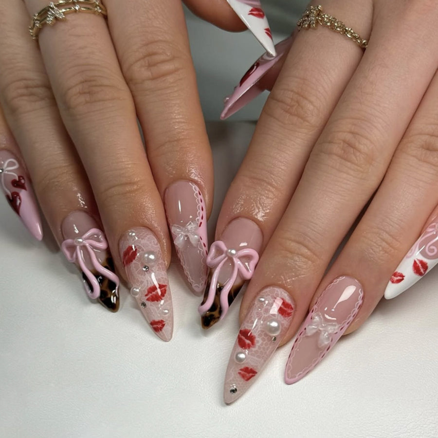 Ongles press-on rose tendre avec nœud, imprimé lèvres rouges et cœurs
