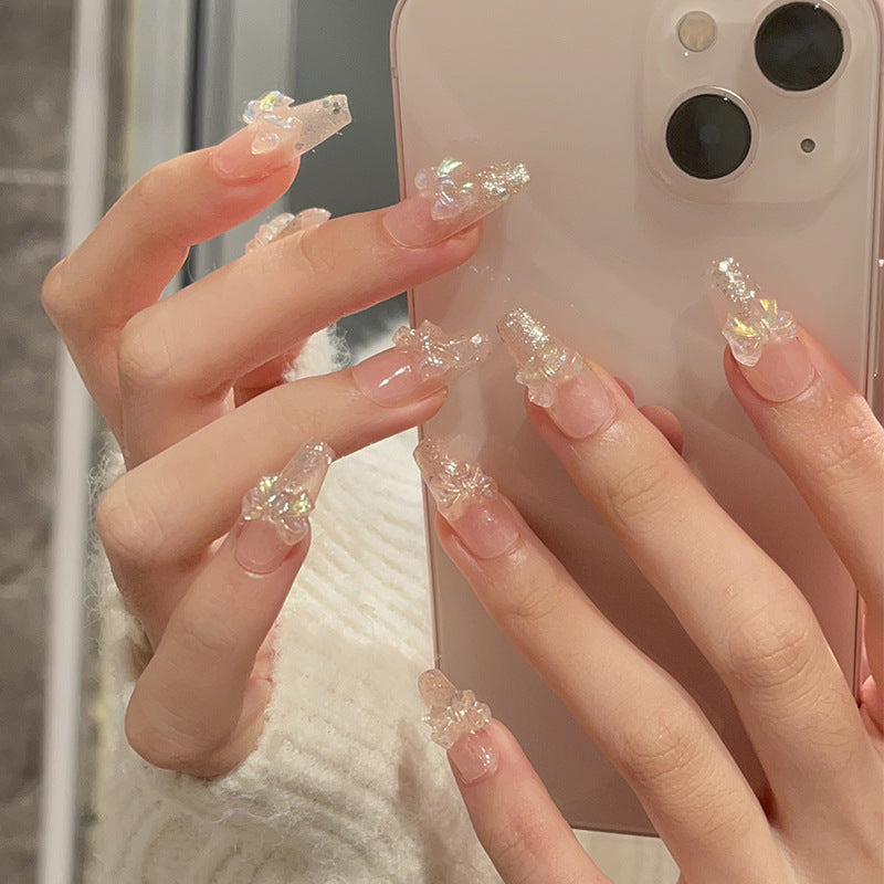Ongles paillettes aurore avec breloques nœud irisé