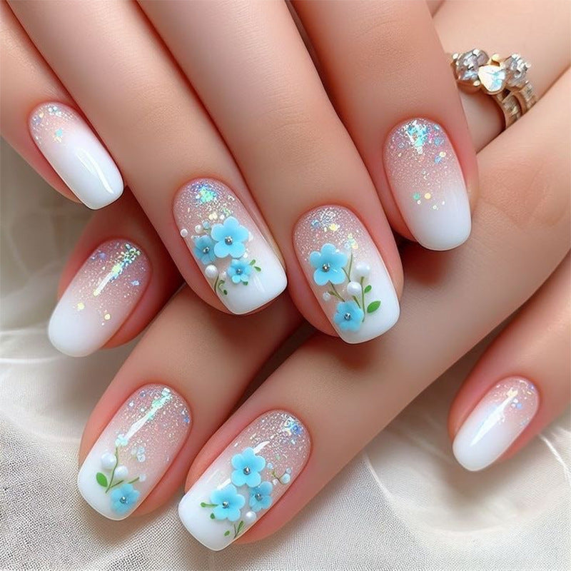 Ongles press-on courts forme carrée simples, dégradé rose et blanc, fleurs bleues fraîches
