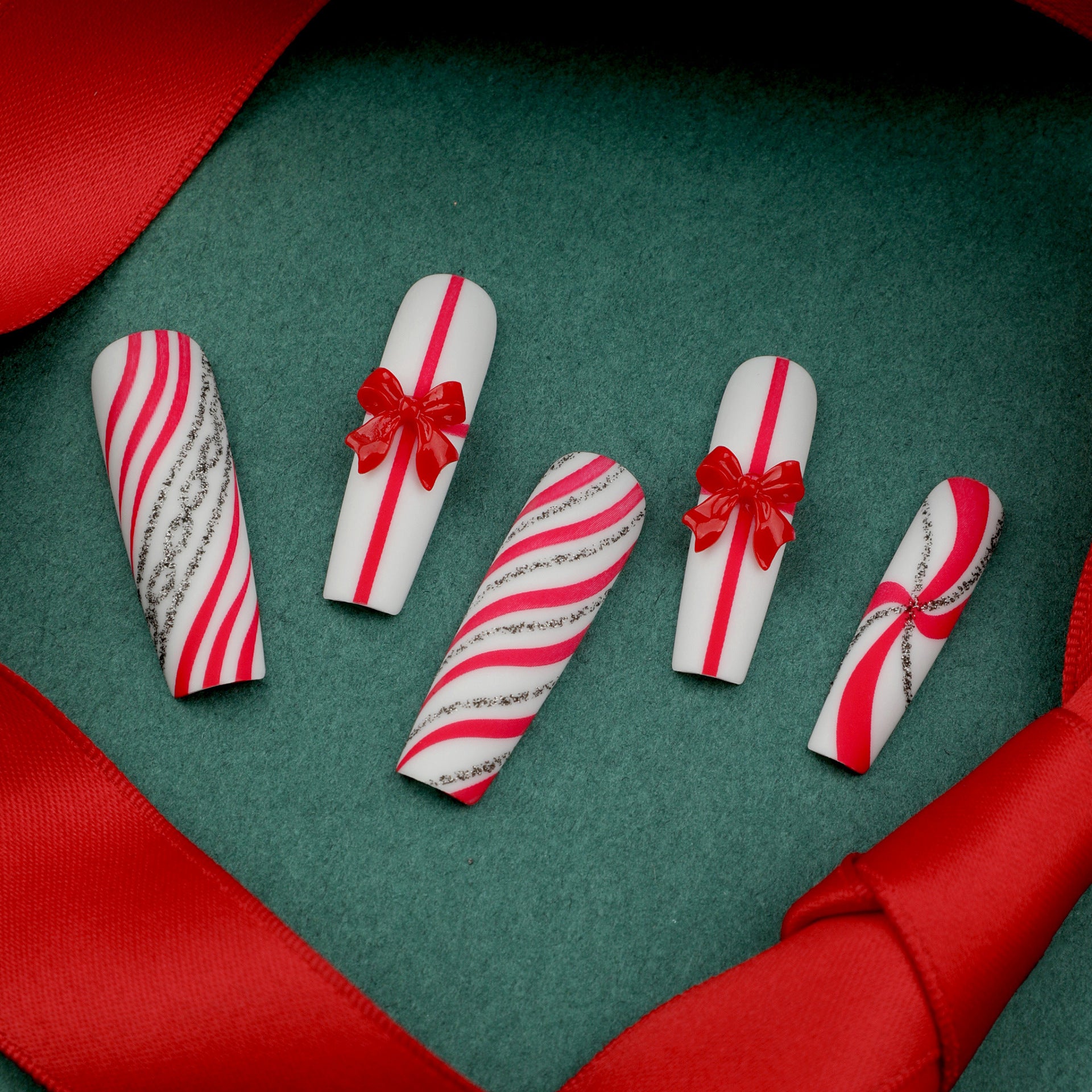 Uñas postizas con lazo rojo extra largo, diseño navideño de rayas con purpurina y caramelos | 365nails