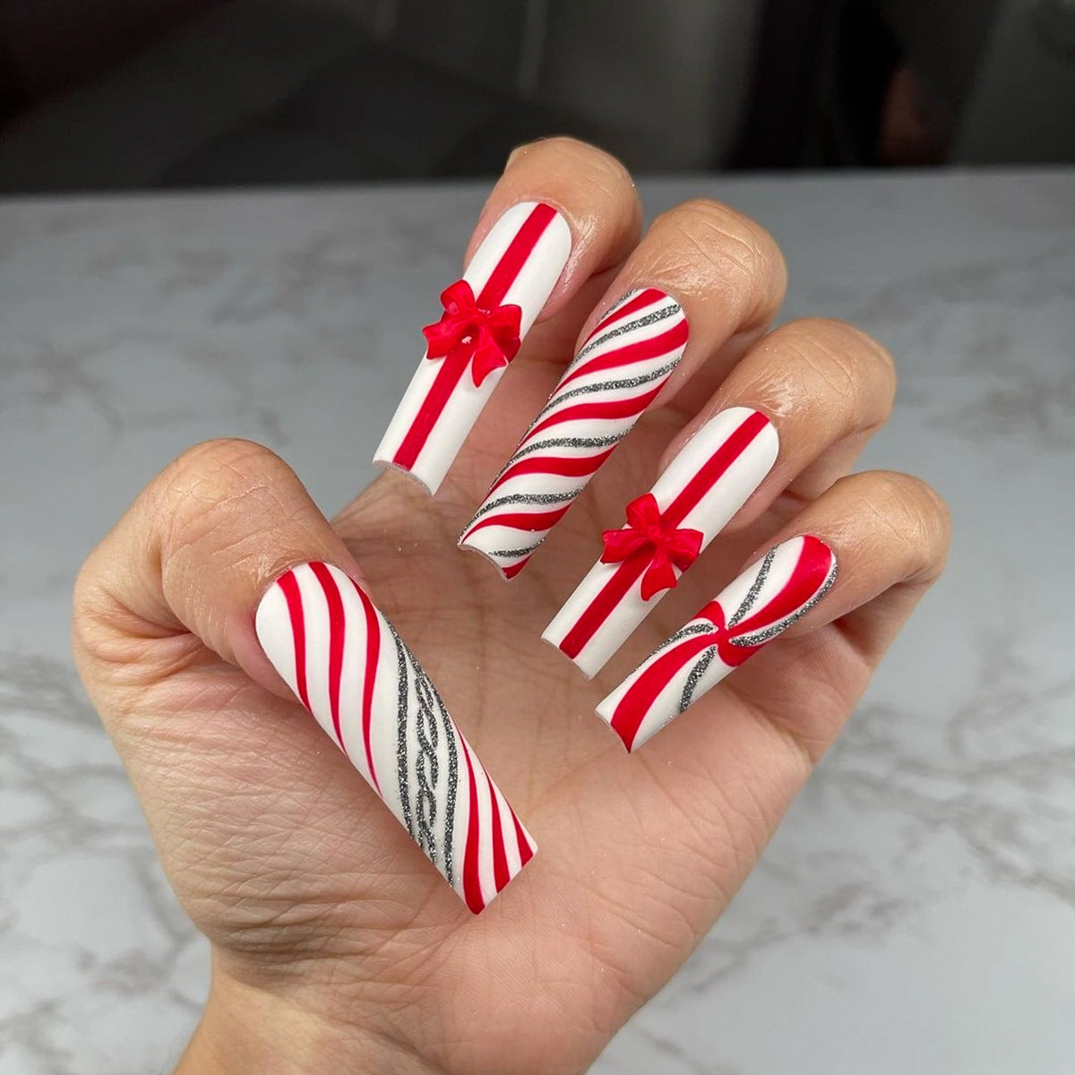 Uñas postizas con lazo rojo extra largo, diseño navideño de rayas con purpurina y caramelos | 365nails