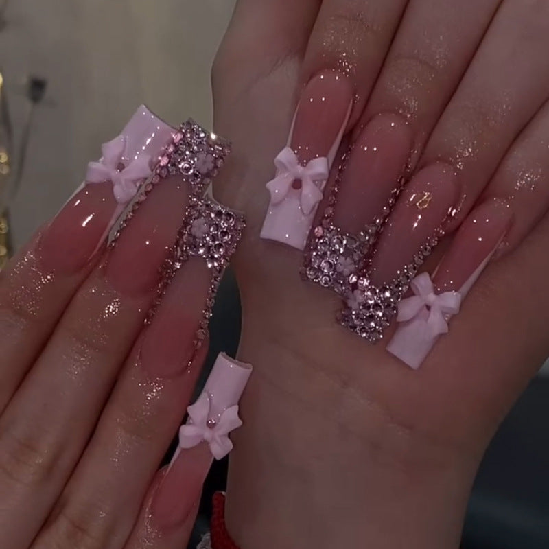 Ongles press-on forme stiletto longs avec nœuds roses et détails en strass