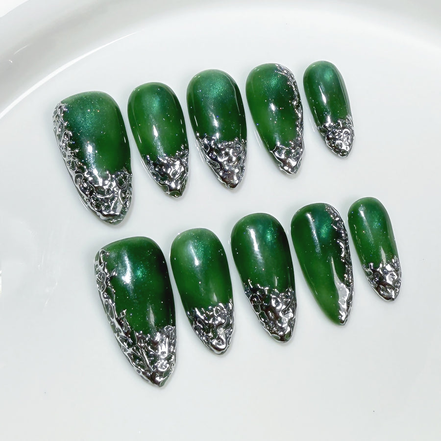 Ongles effet cat-eye émeraude avec bords métalliques irréguliers