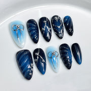 Hand-Painted Blue Gradient Nails with Sculpted Metallic Bow Accents