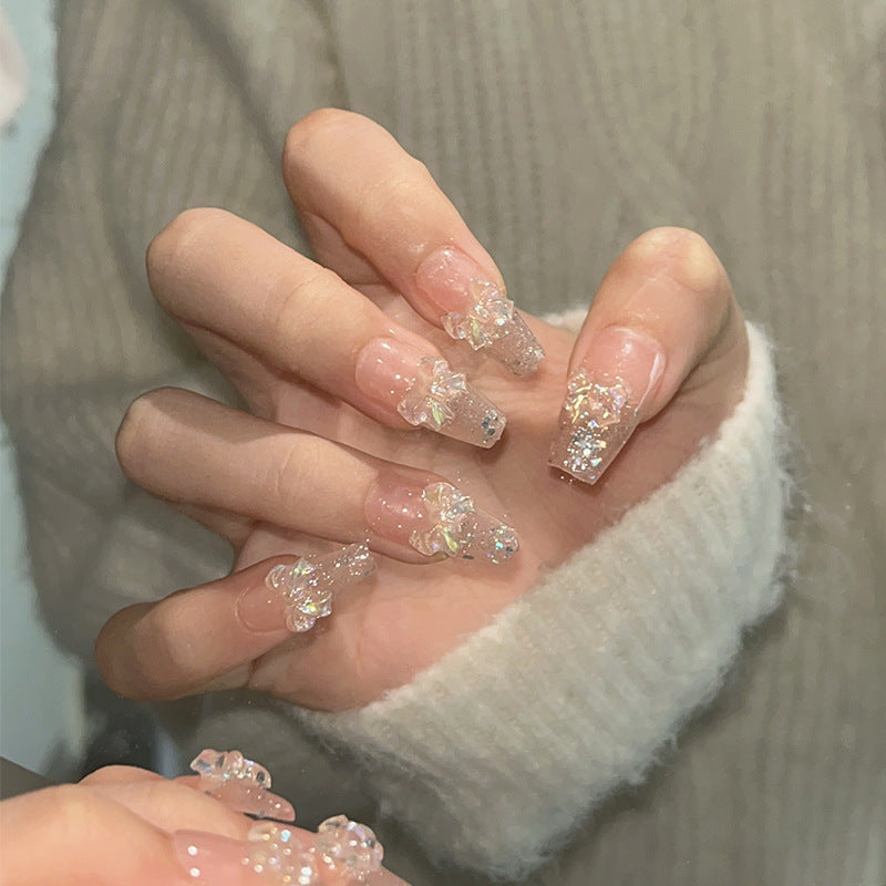Ongles paillettes aurore avec breloques nœud irisé