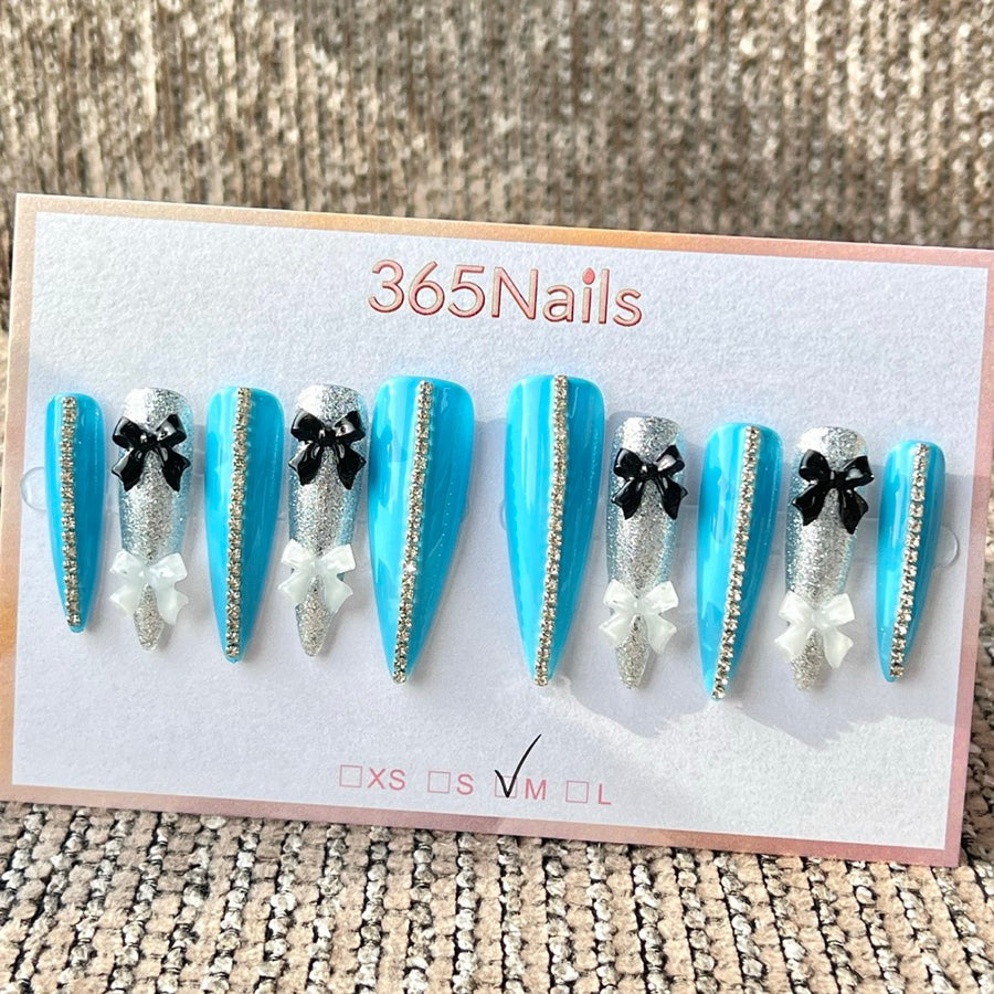 365nails — Ongles press-on longs forme stiletto, faits main, strass en forme de nœud bleu et argent