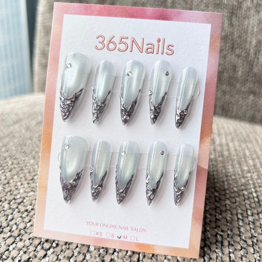 Femme Fatale : « Armure au clair de lune » – base œil de chat bleu glacé avec pointes chrome liquide argent 3D et strass — ongles press-on longs forme stiletto