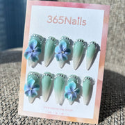 Flora Esculpida: "Orquídea Mística de Menta" – Flores em Degradê Azul-Roxo em 3D em Unhas Stiletto Verde Sálvia com Glitter