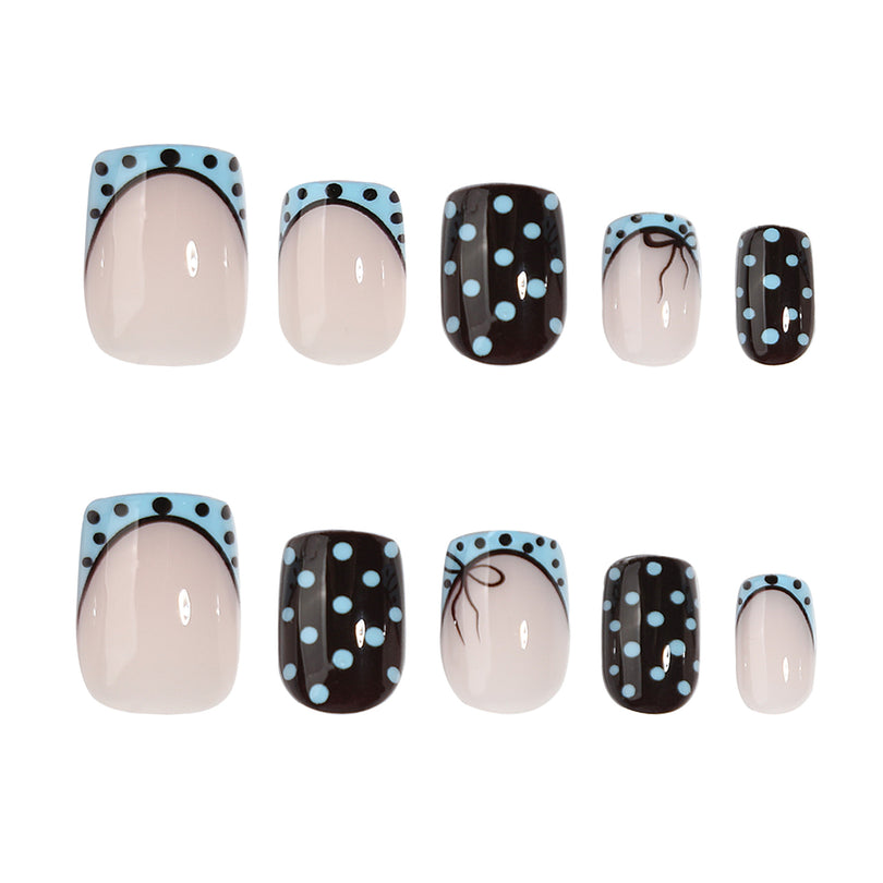 Two views of short square press-on nails with blue french tips and black polka dot designs