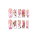 Nude pink gradient to pink and white French style with gold embellishment and three-dimensional knot press on nail