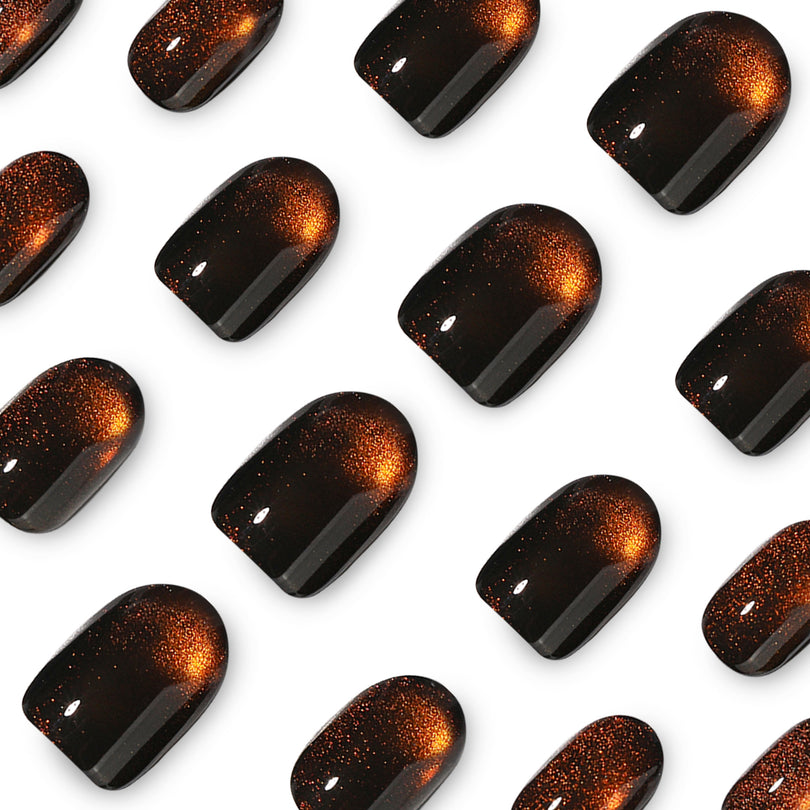 Close-up grid of brown cat-eye press-on nail tips with orange glow and glossy finish