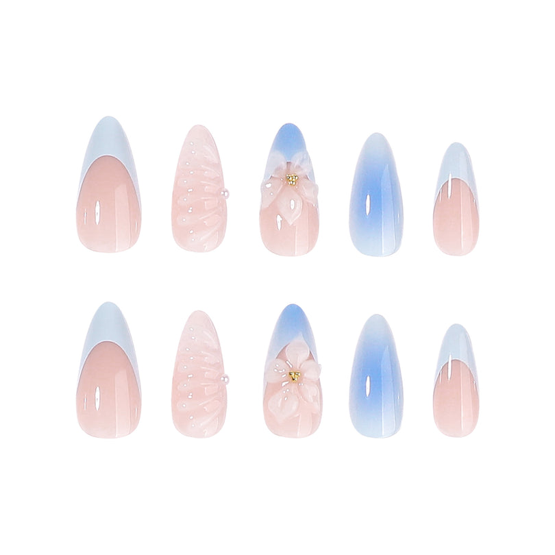 Two rows of press-on nails with French tips, blue gradient accents and 3D flower charms