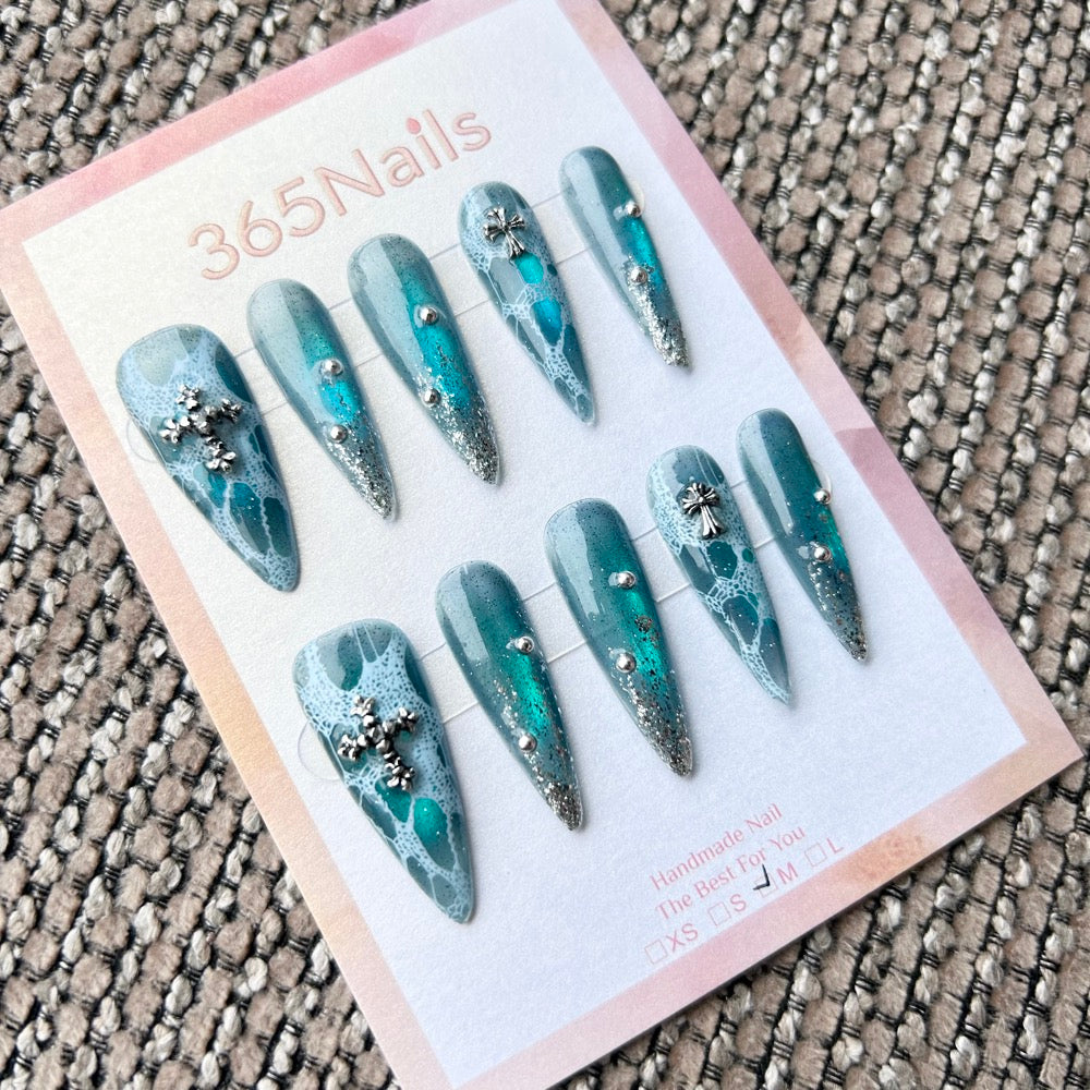Femme Fatale: "Abyssal Lace" – Deep Teal Aura with White Lace Pattern, Silver Glitter Tips & Cross Charms Long Stiletto Nails