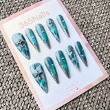 Femme Fatale: "Abyssal Lace" – Deep Teal Aura with White Lace Pattern, Silver Glitter Tips & Cross Charms Long Stiletto Nails