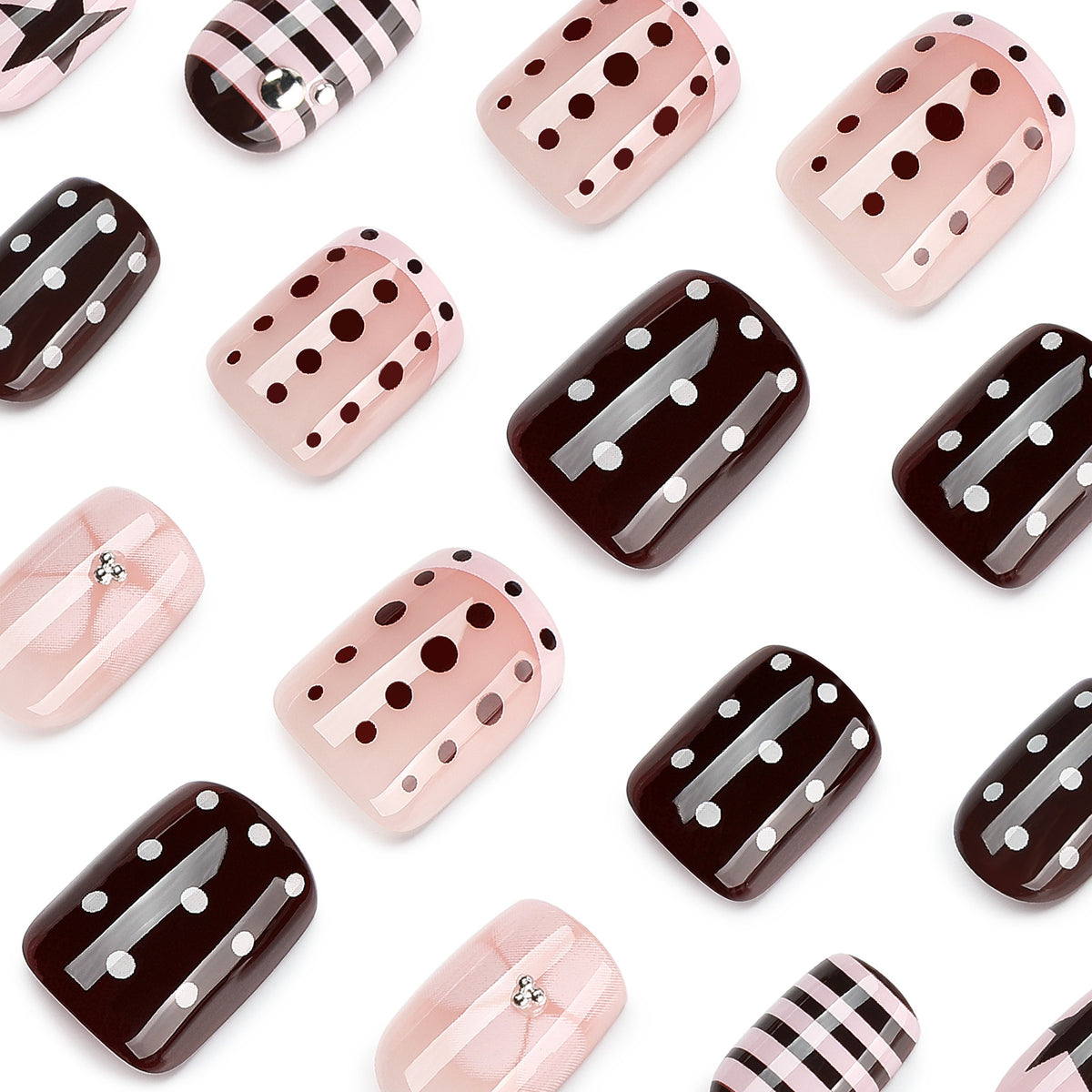 Close-up of scattered press-on nails with polka dot, striped, and plaid designs.
