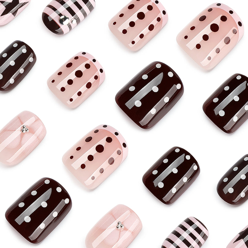 Close-up of scattered press-on nails with polka dot, striped, and plaid designs.