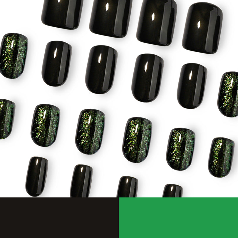 Black and green cat-eye press-on nails arranged on white background