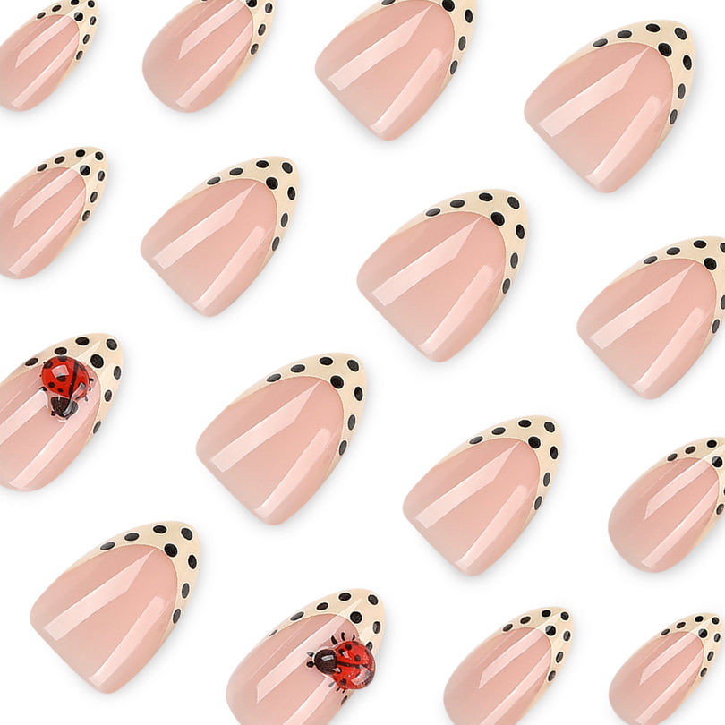 Scattered almond press-on nails with cream french tips, black dots and red 3D ladybug accents