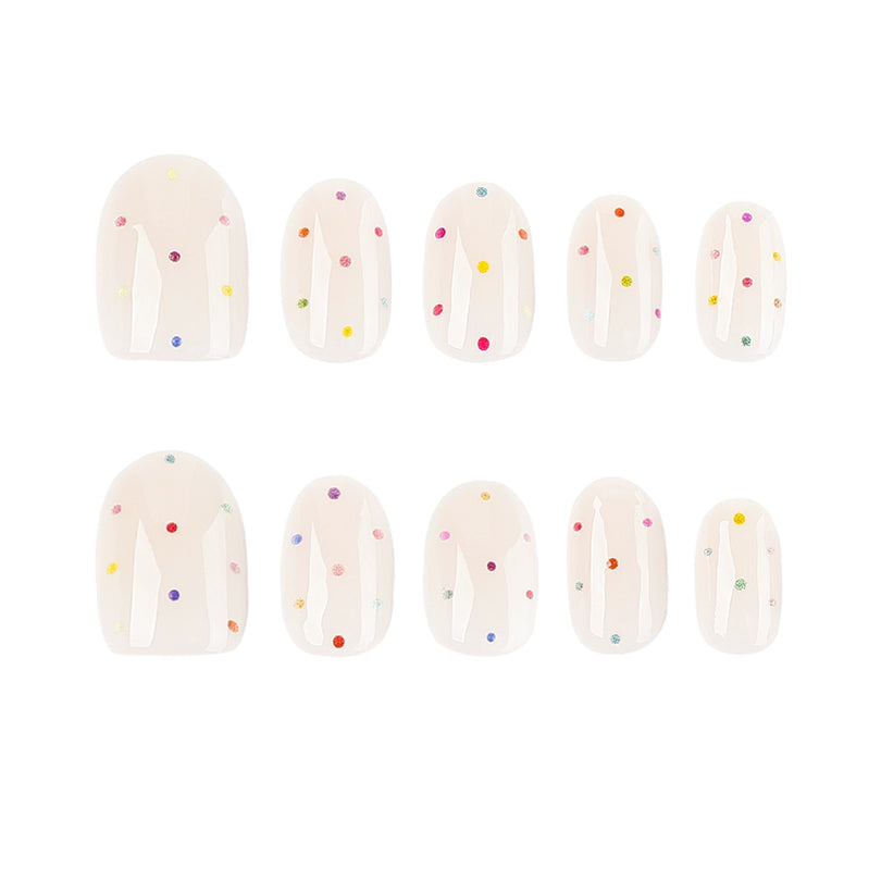 Two rows of short round press-on nails with colorful polka dots on a sheer base.