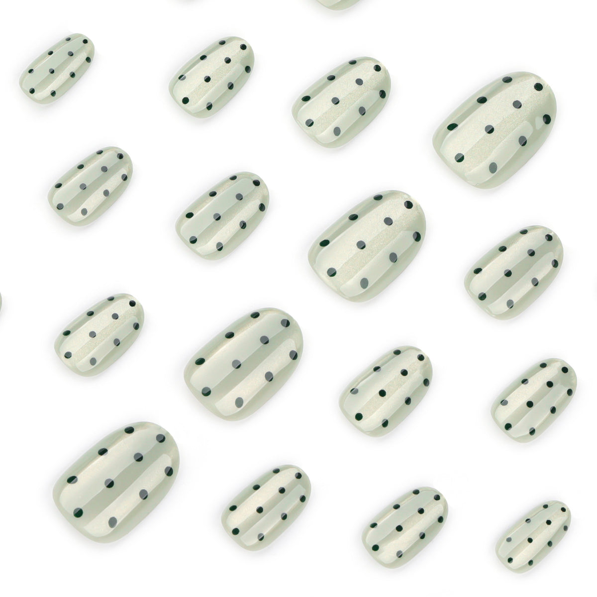 Close-up of sheer green cat-eye press-on nails with black dots