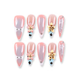 Uñas postizas 365Nails color nude-coral gris degradado con flores doradas 3D y detalles de perlas francesas.