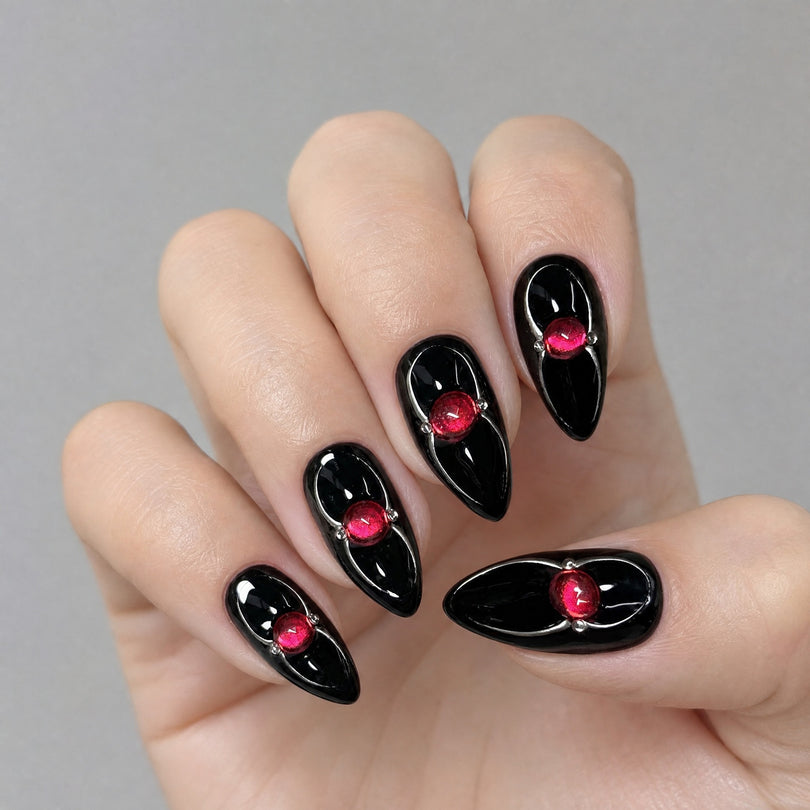 Black almond with red gem press on nails worn on hand